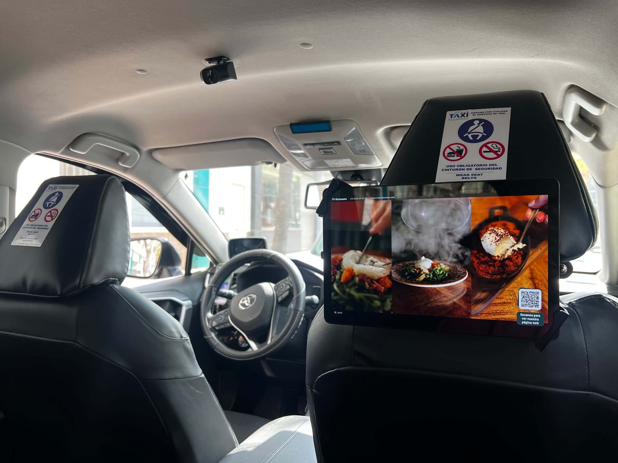 Tablet Relevont en reposacabezas de taxi mostrando anuncio de restaurante